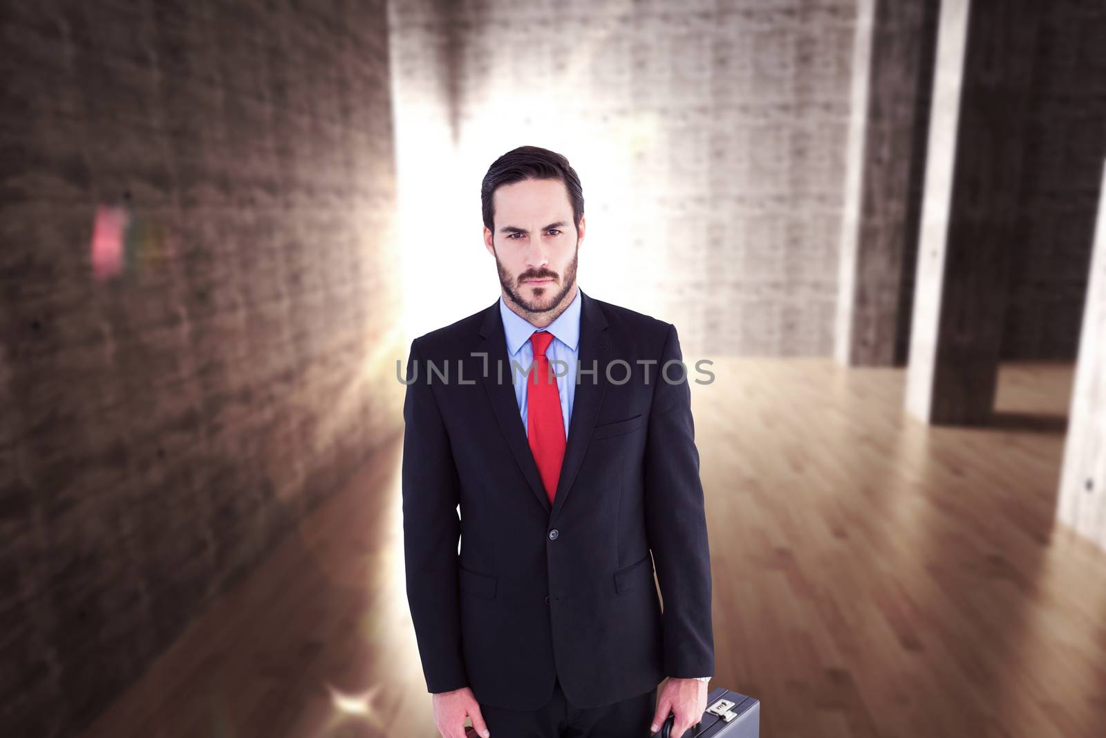 Composite image of serious handsome businessman holding briefcase by Wavebreakmedia