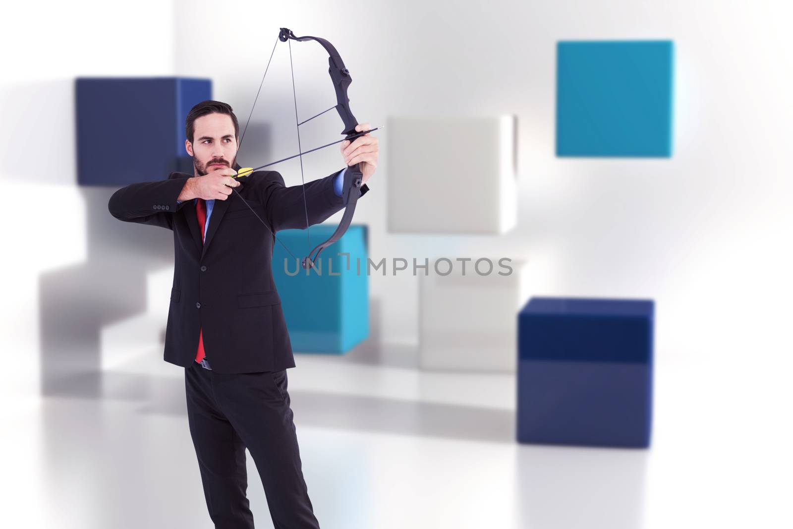 Focused businessman shooting a bow and arrow against abstract background