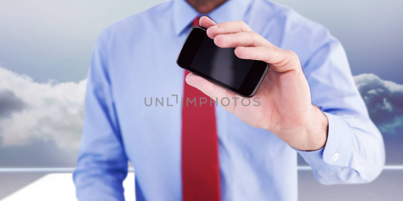 Hand of businessman showing smartphone against clouds in a room