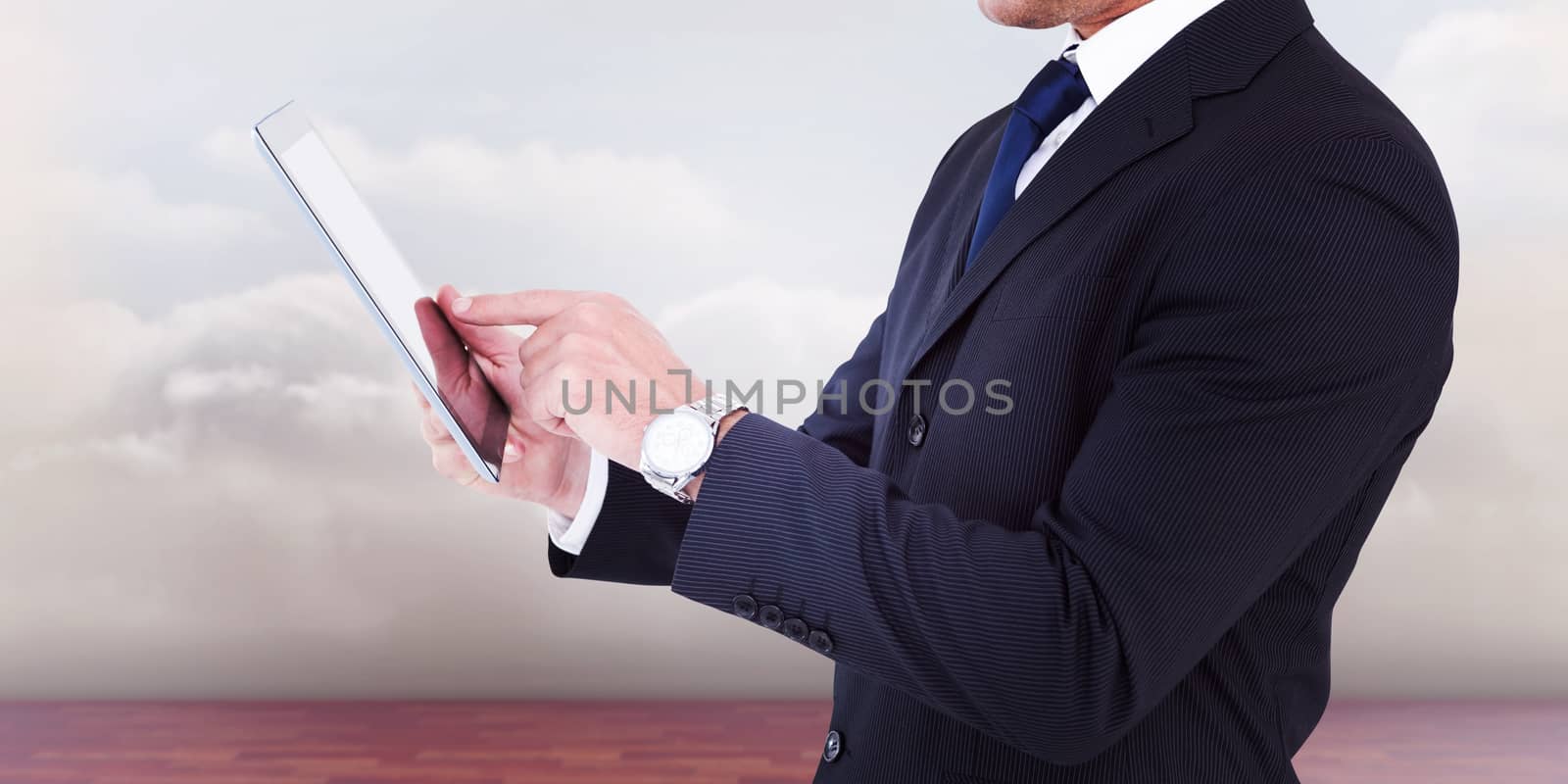 Businessman in suit using digital tablet against clouds in a room