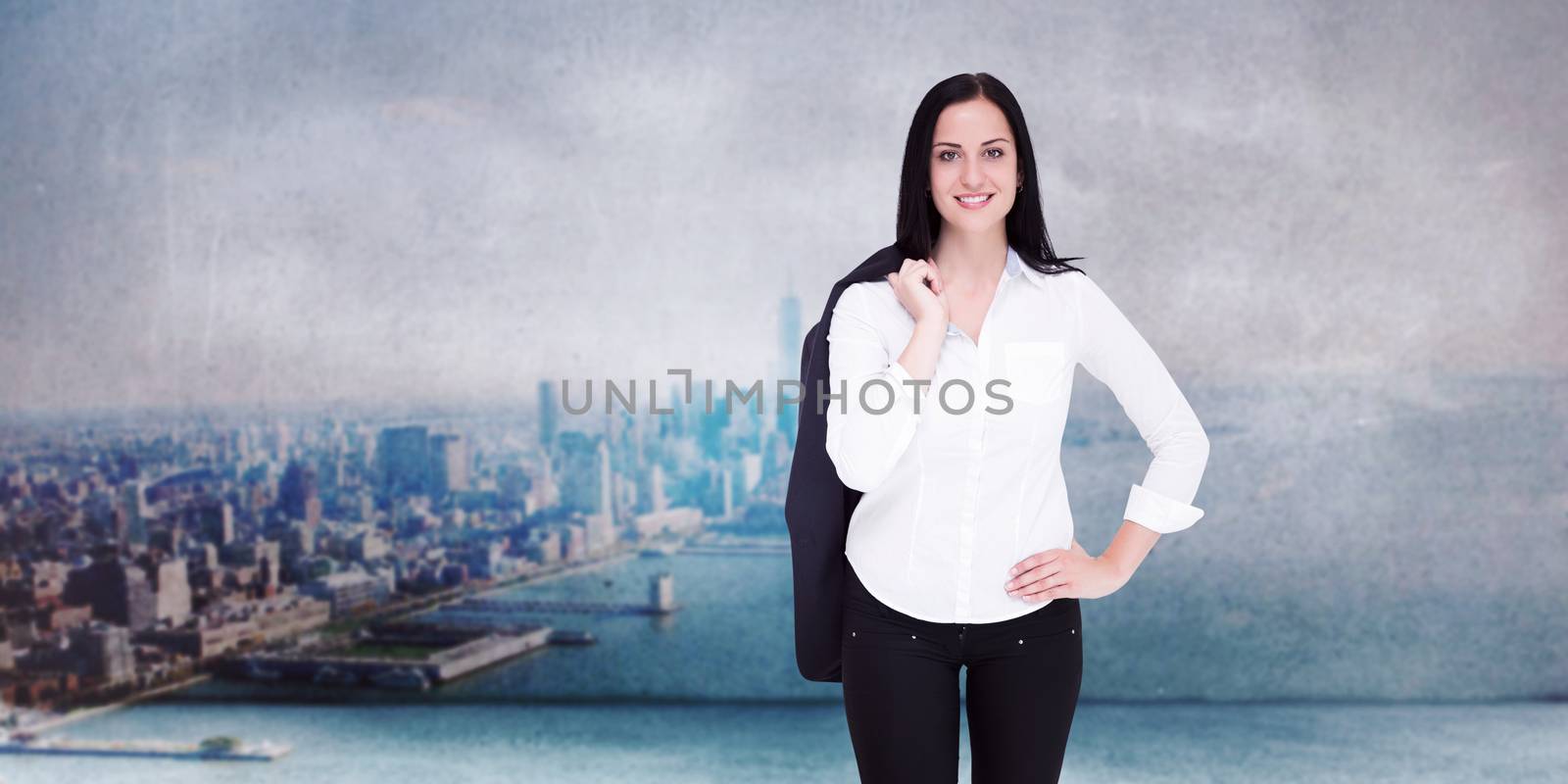 Pretty businesswoman smiling at camera against city scene in a room