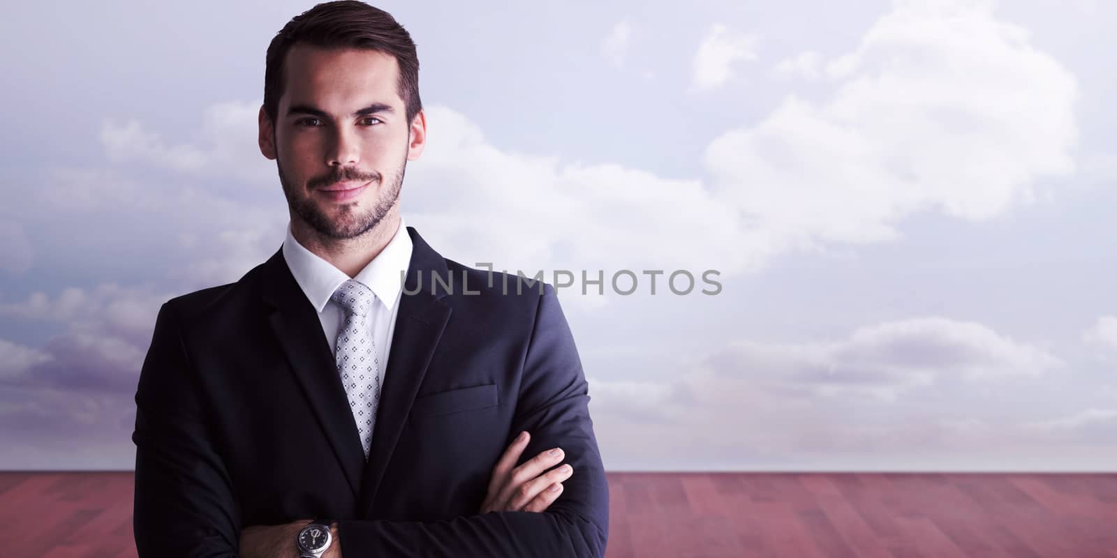 Smiling businessman posing with arms crossed against clouds in a room