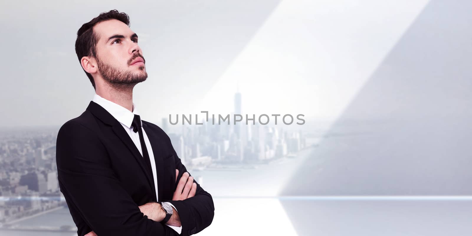 Thinking businessman with his arms crossed against city scene in a room