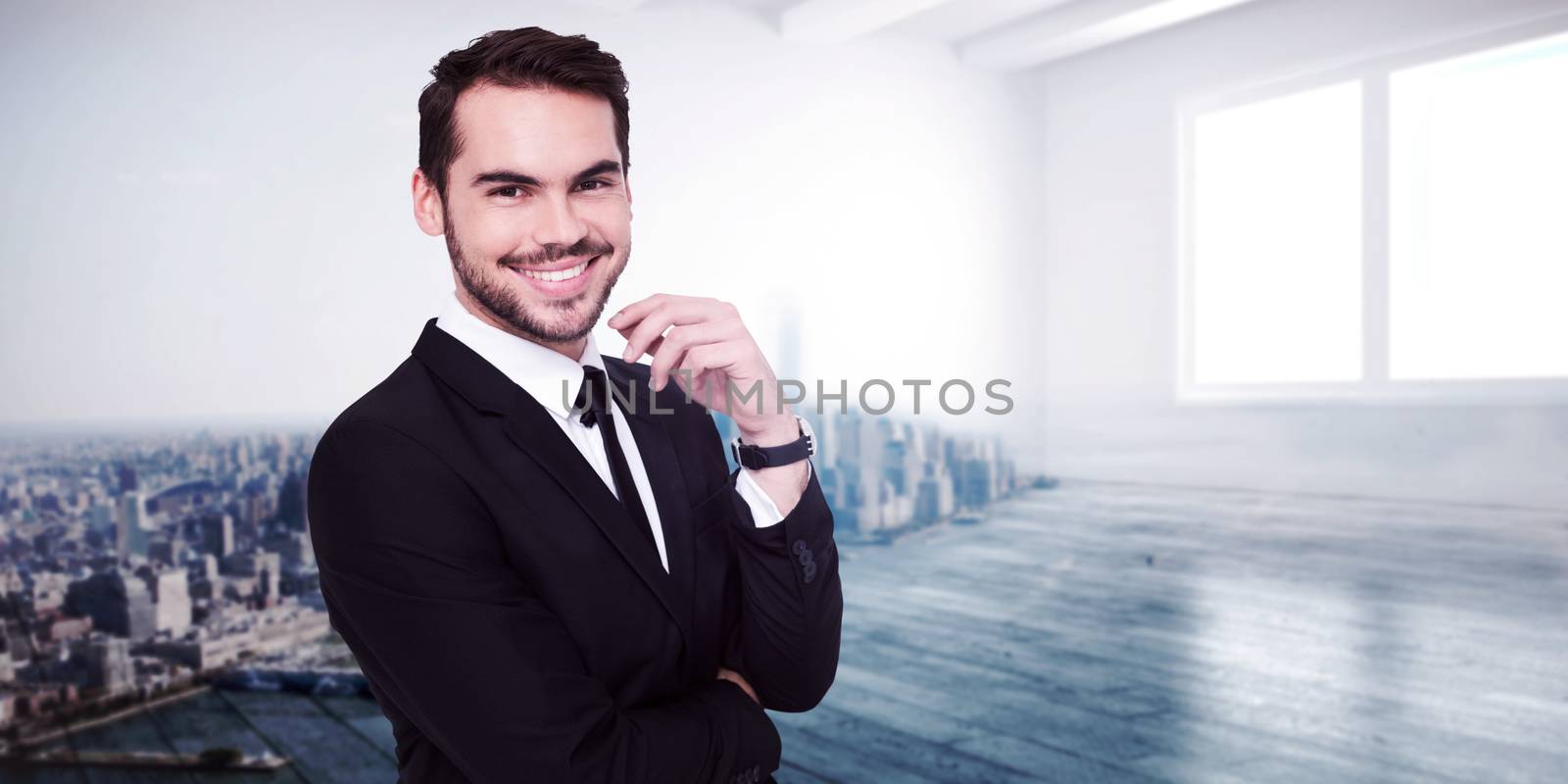 Stylish businessman smiling at camera against city scene in a room
