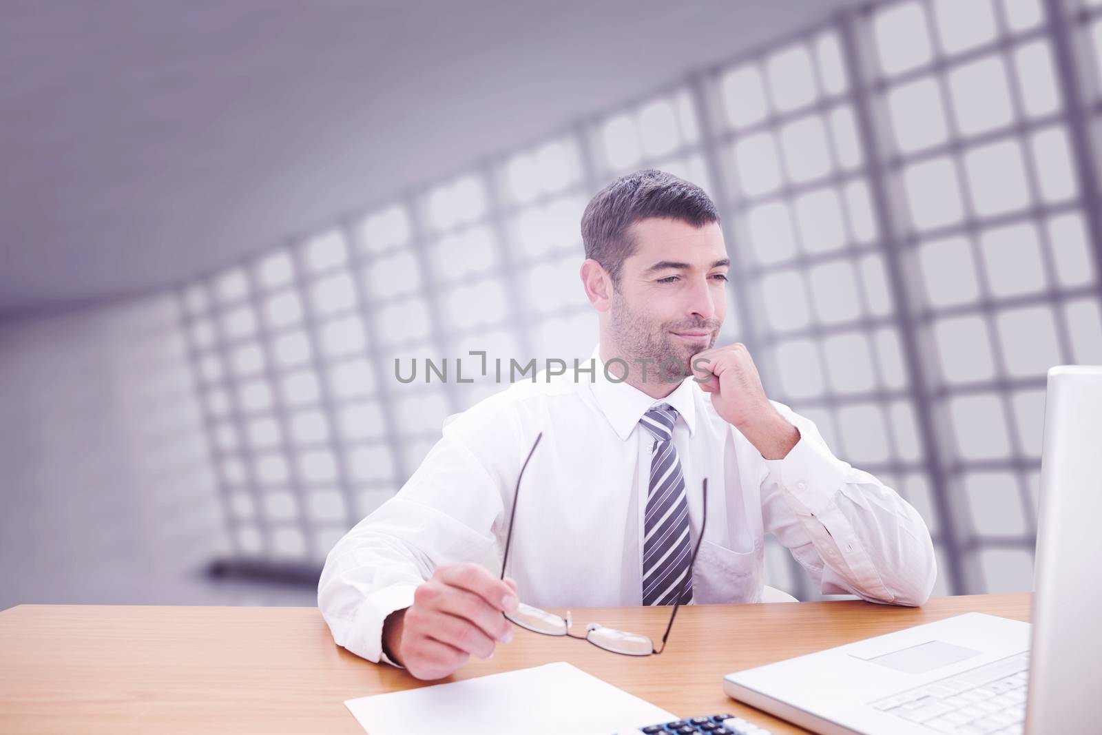 Businessman using laptop against abstract room