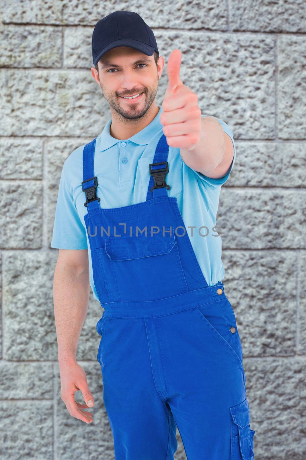 Repairman gesturing thumbs up against grey brick wall