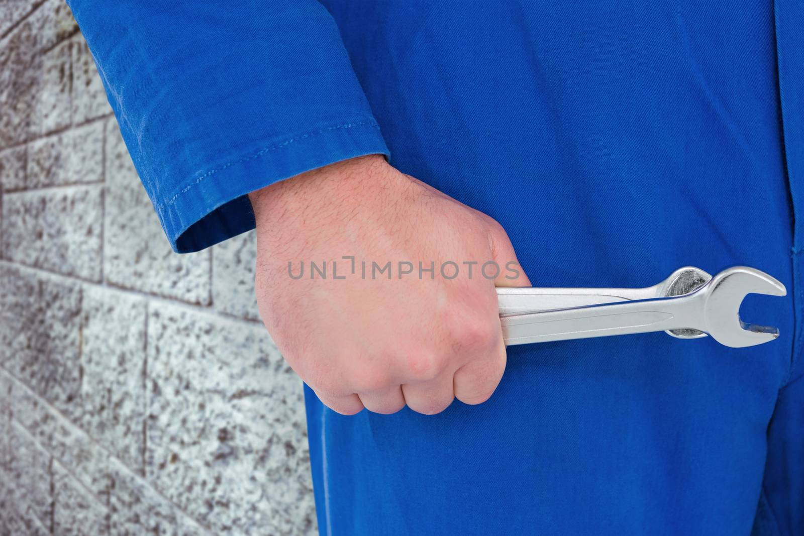 Composite image of mechanic holding spanners on white background by Wavebreakmedia