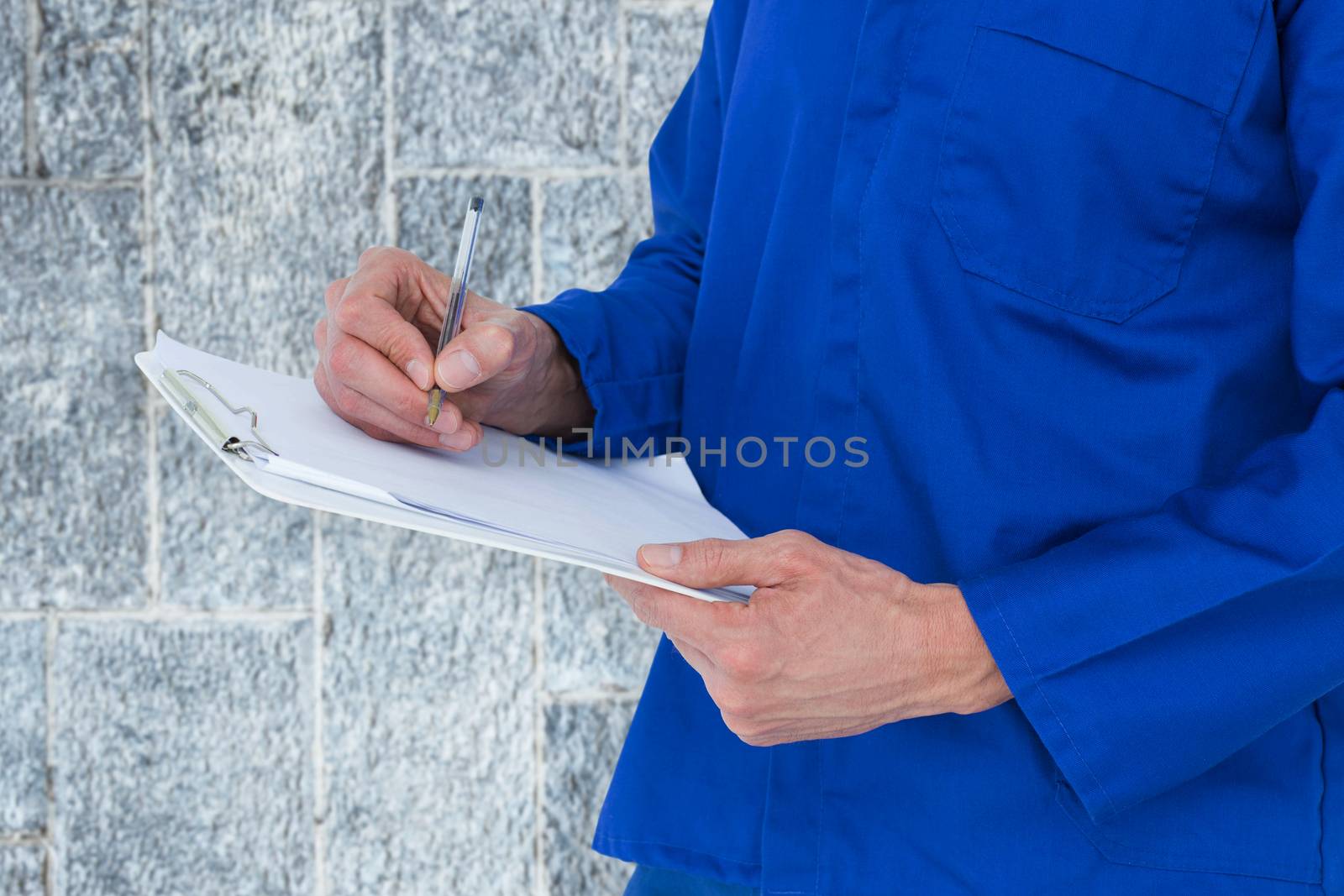 Composite image of mechanic writing notes on clipboard by Wavebreakmedia