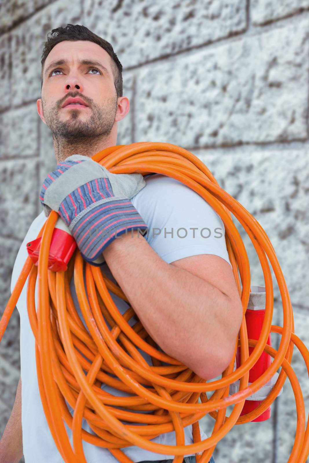 Composite image of repairman holding wire roll by Wavebreakmedia