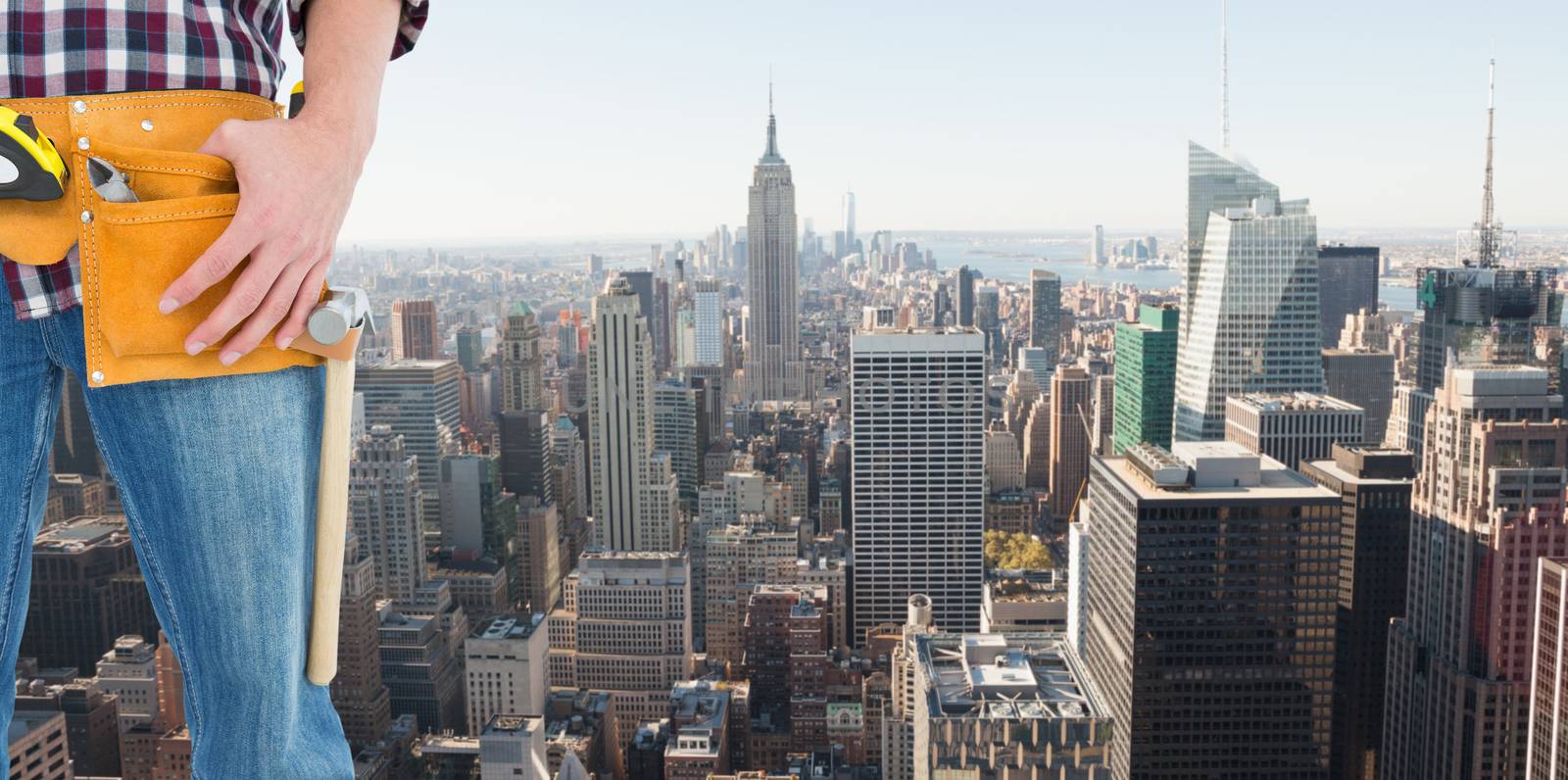 Handyman wearing tool belt against new york