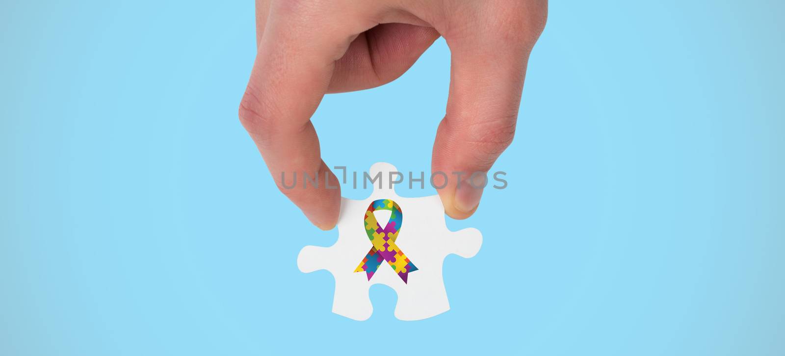 Hand holding jigsaw piece against blue background with vignette