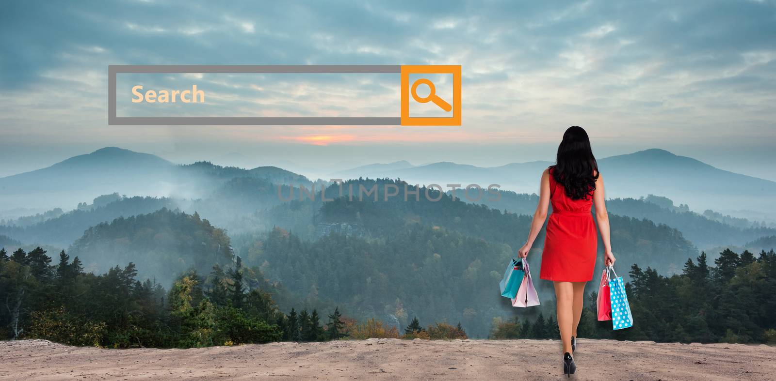 Woman standing with shopping bags against misty landscape