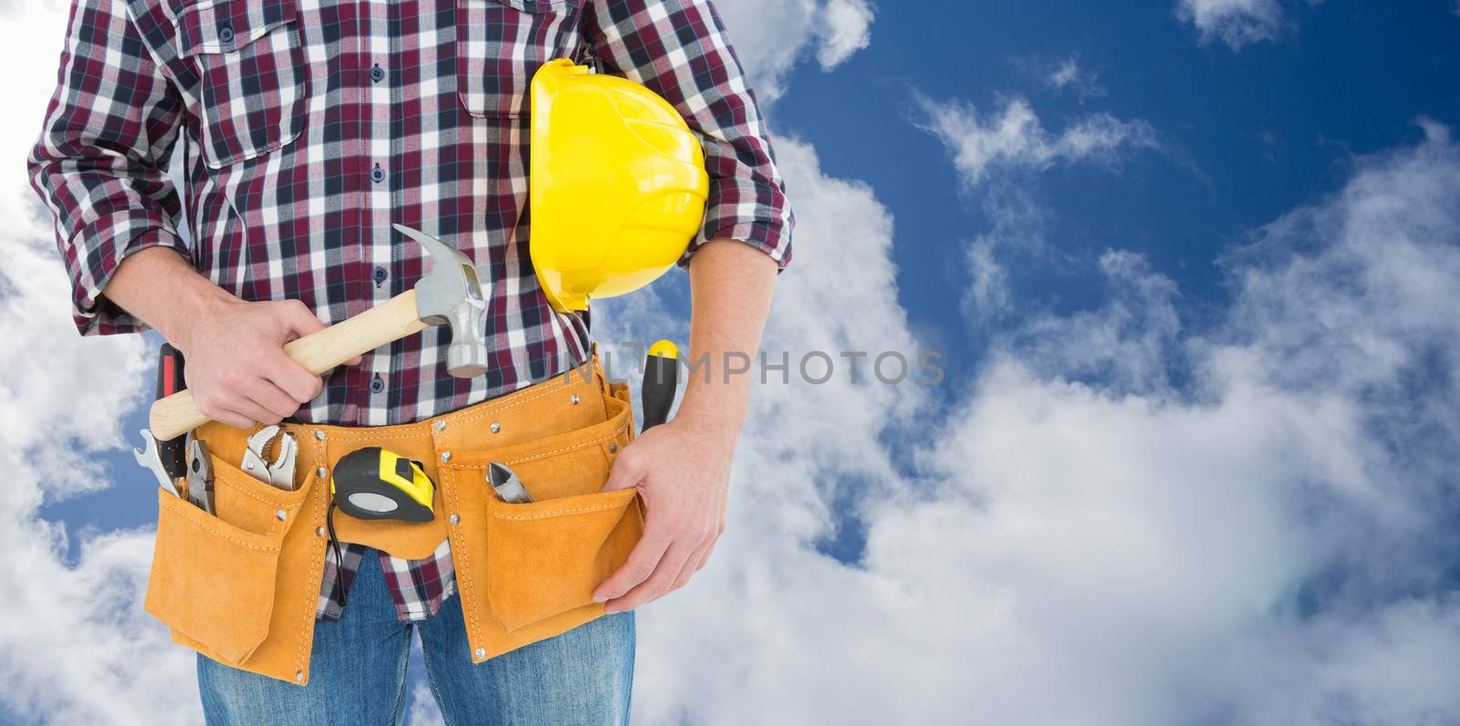 Repairman with hard hat and hammer against bright blue sky with clouds