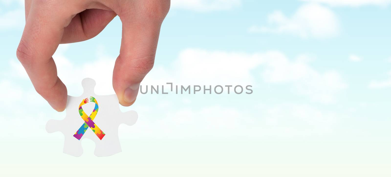 Hand holding jigsaw piece against blue sky
