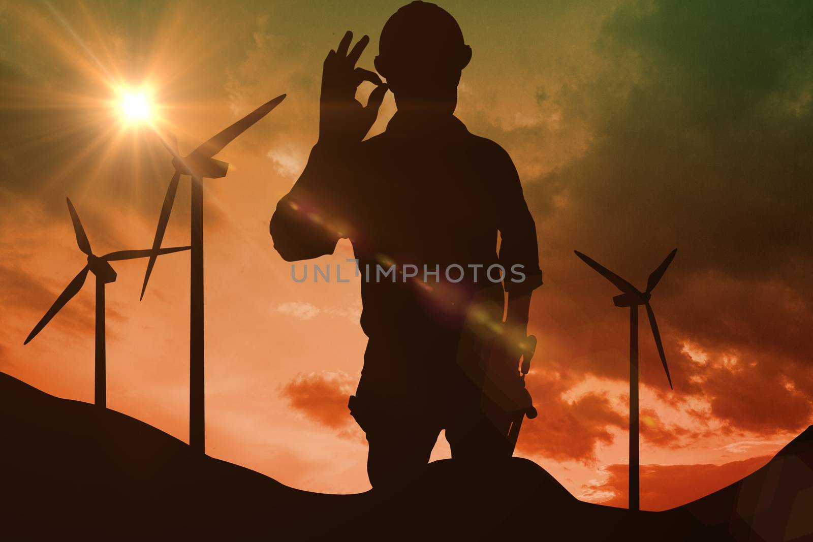 Handyman gesturing okay against sky and mountains