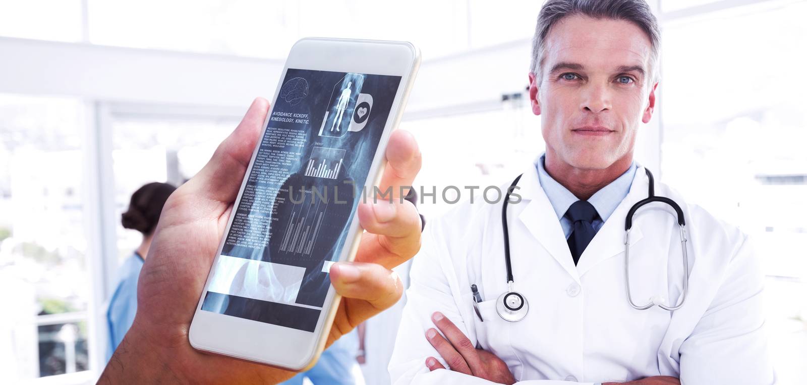 hand holding smartphone against smiling doctor with arms crossed