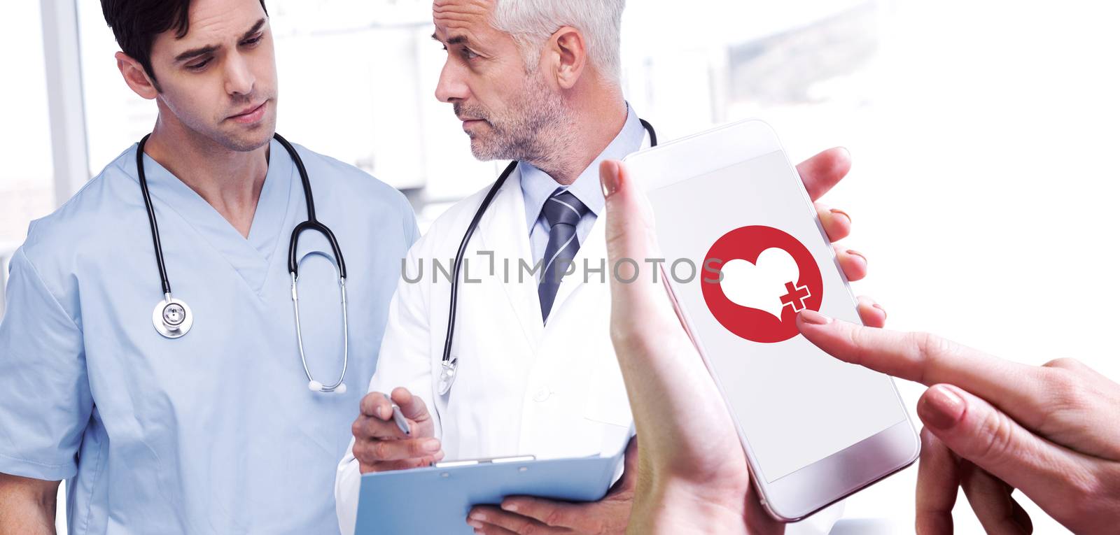Hand holding smartphone against doctors talking about a file
