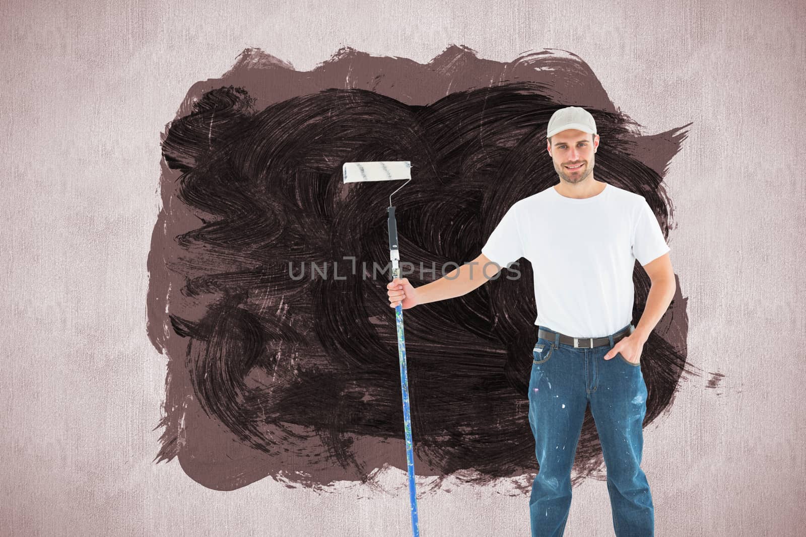 Confident man holding paint roller on white background against white and grey background