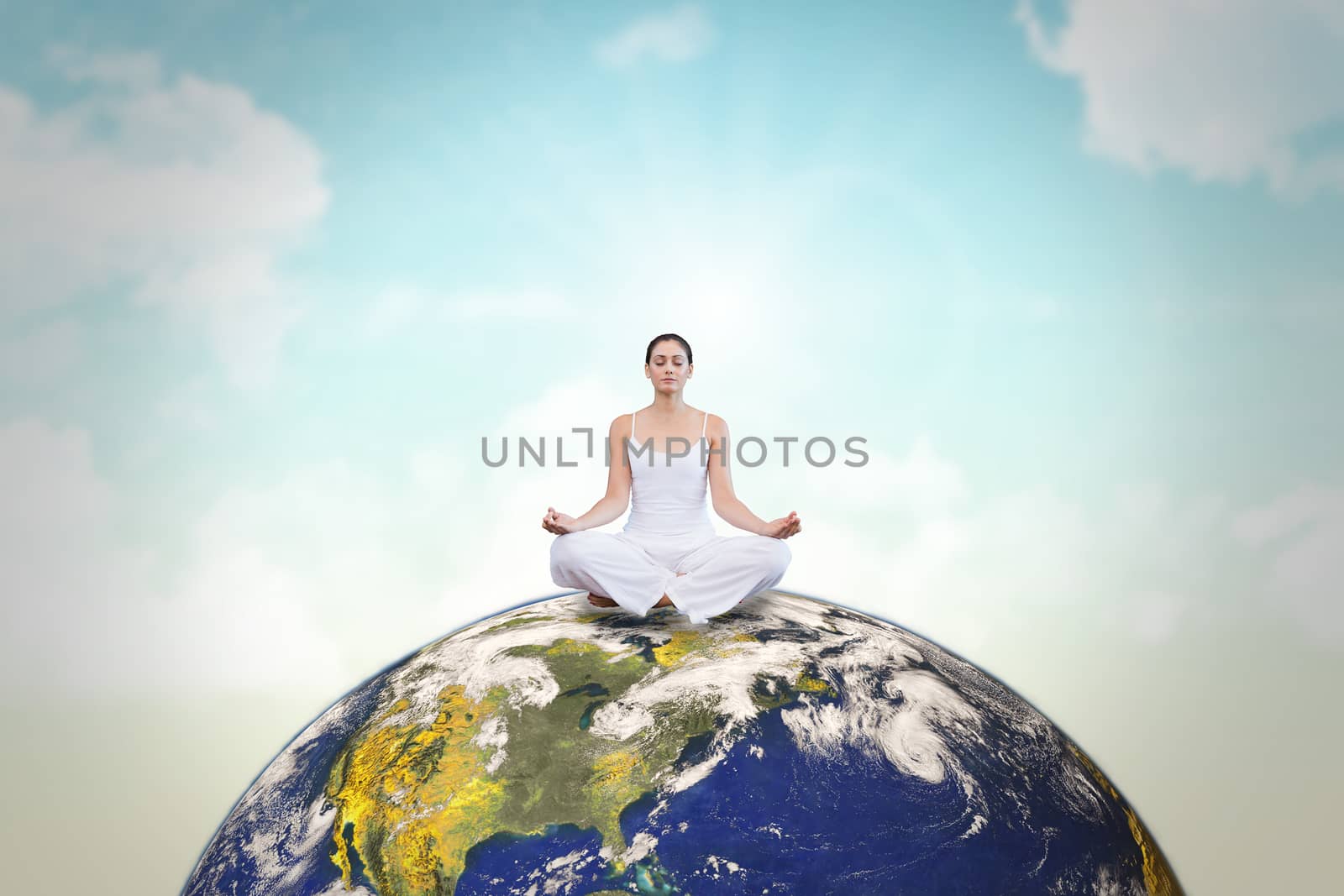 Composite image of peaceful woman in white sitting in lotus pose by Wavebreakmedia