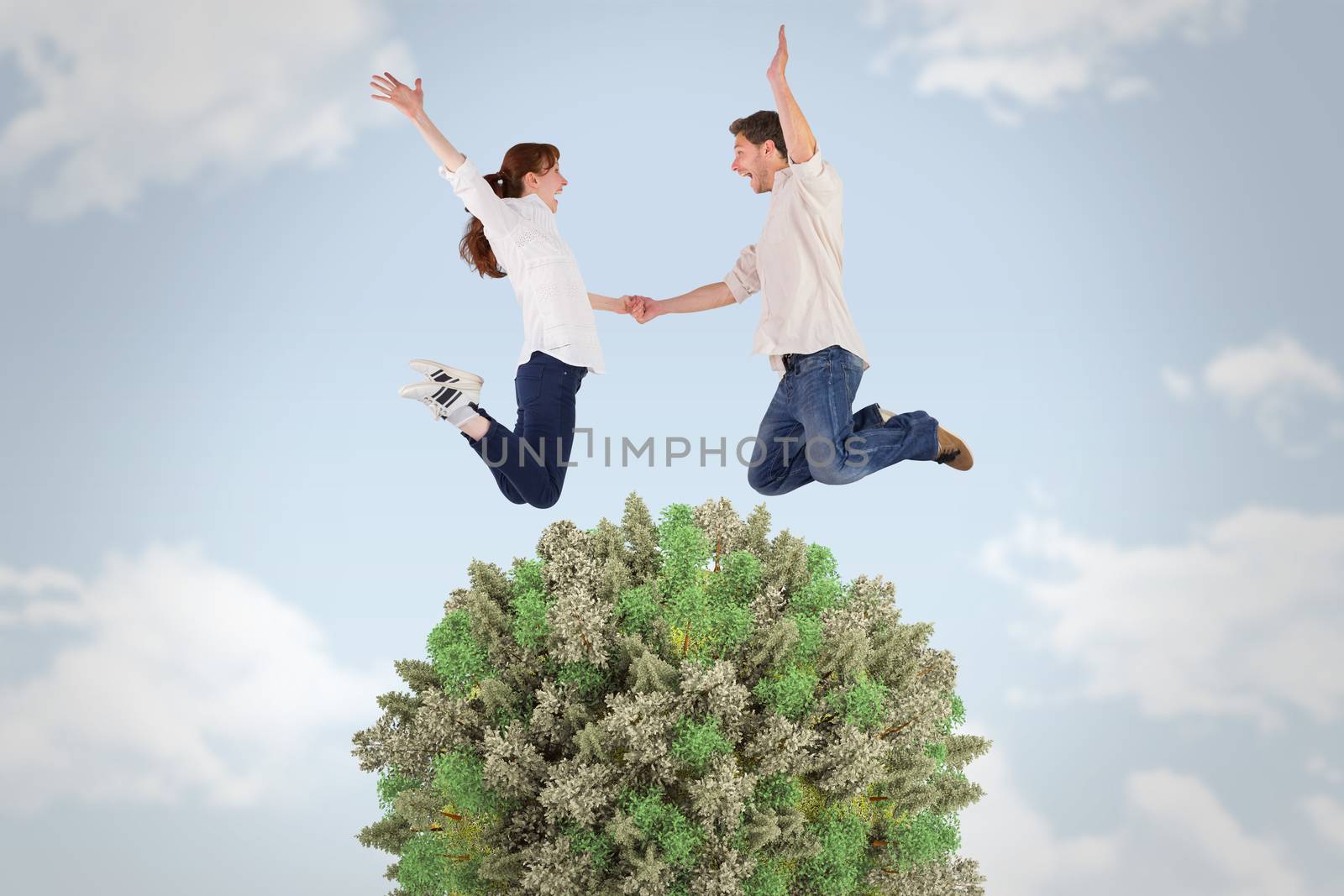 Couple jumping and holding hands against blue sky