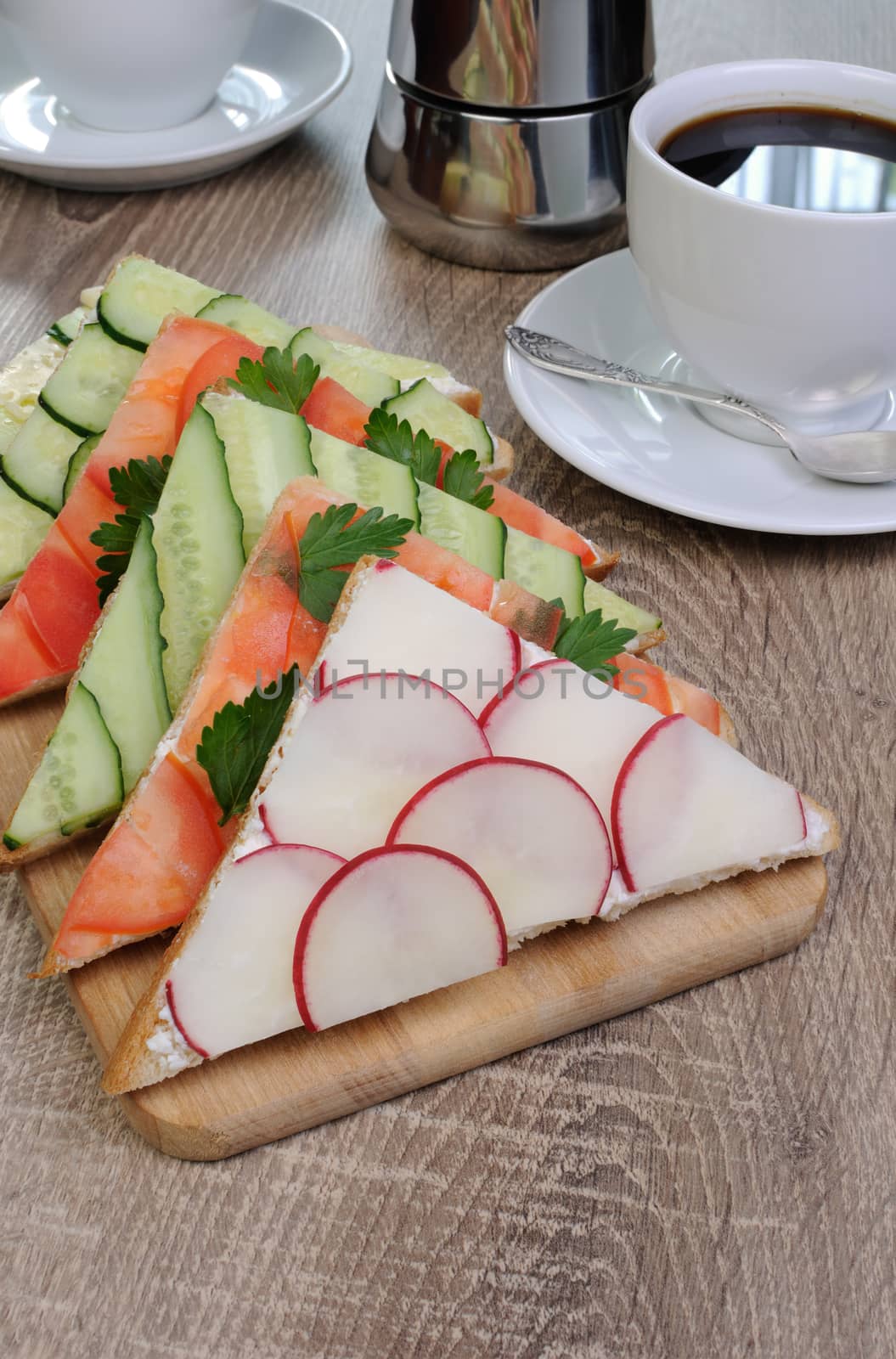 variety of vegetable sandwiches on a table with cup of coffee