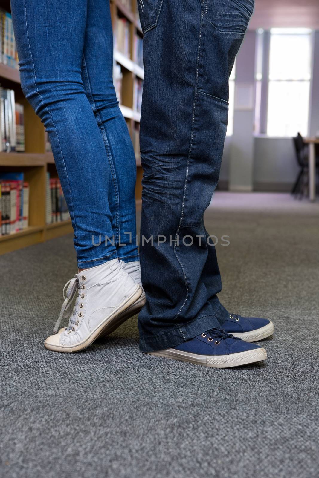 Students standing back-to-back in the library  by Wavebreakmedia
