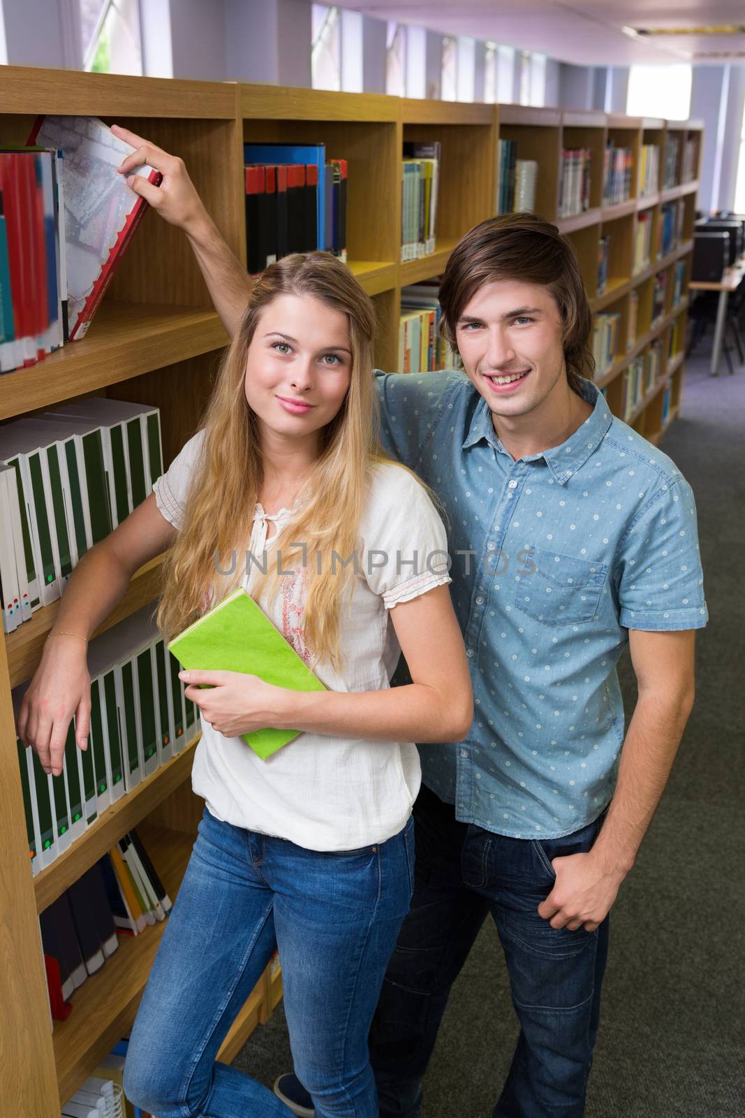 Students smiling at camera in the library in the university 