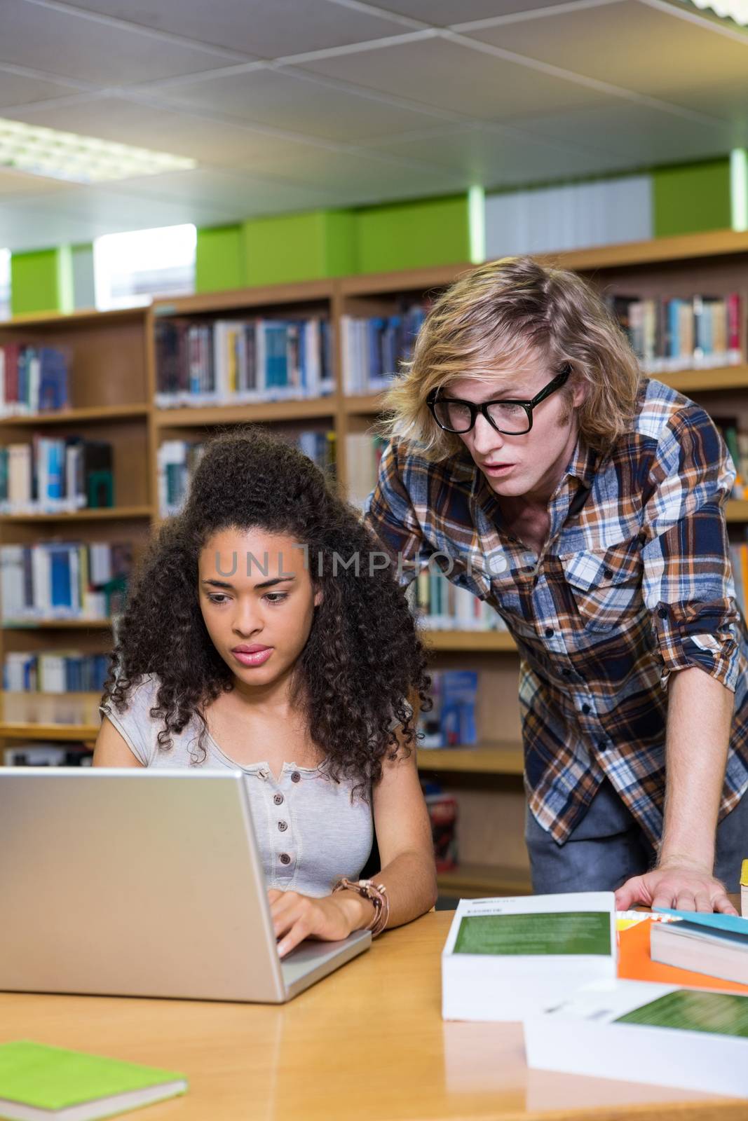 Student getting help from classmate in library at the university