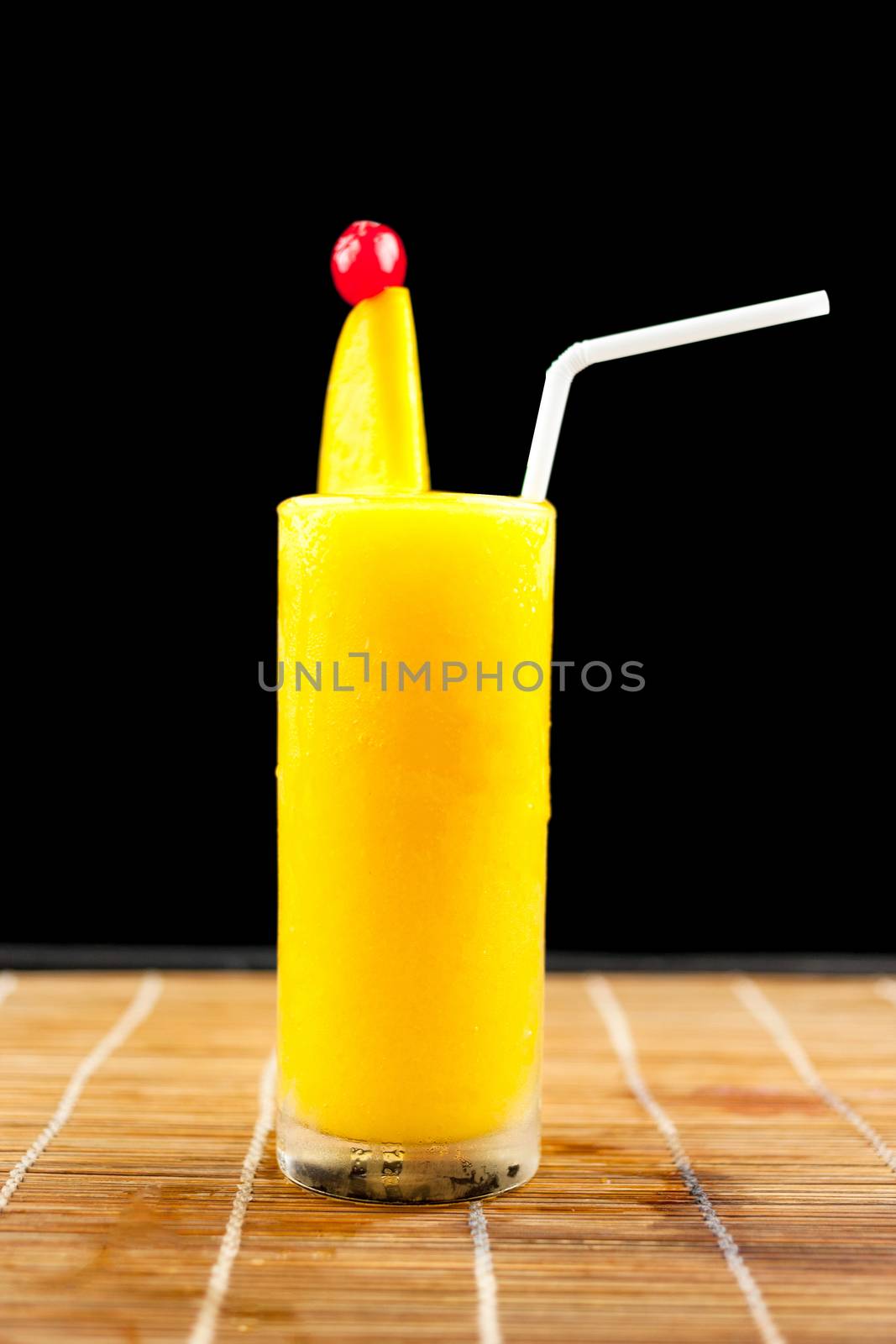 Mango juice and fruit on glass isolation black background by nopparats