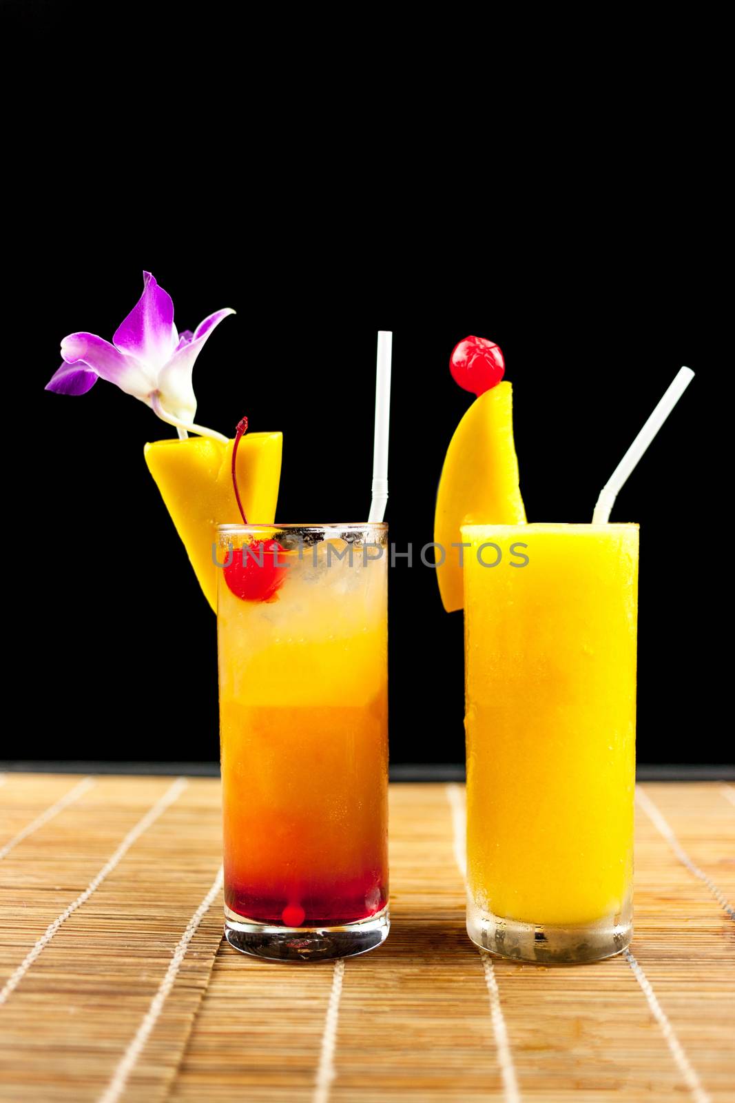 Mango juice and juice soda with fruit on glass isolation black background .