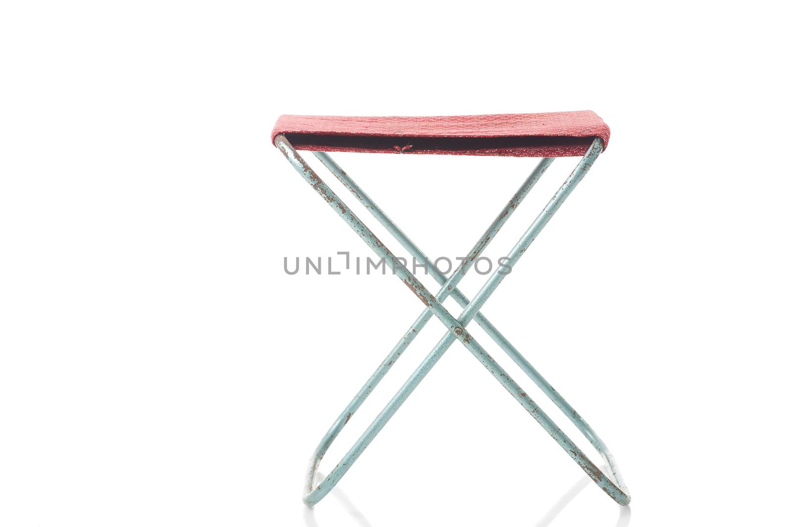 Simple folding canvas stool with a textile seat standing open, front view isolated on white, portable for use at picnics and camping