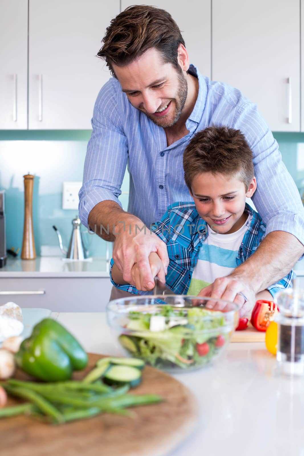 Happy family preparing vegetables together by Wavebreakmedia