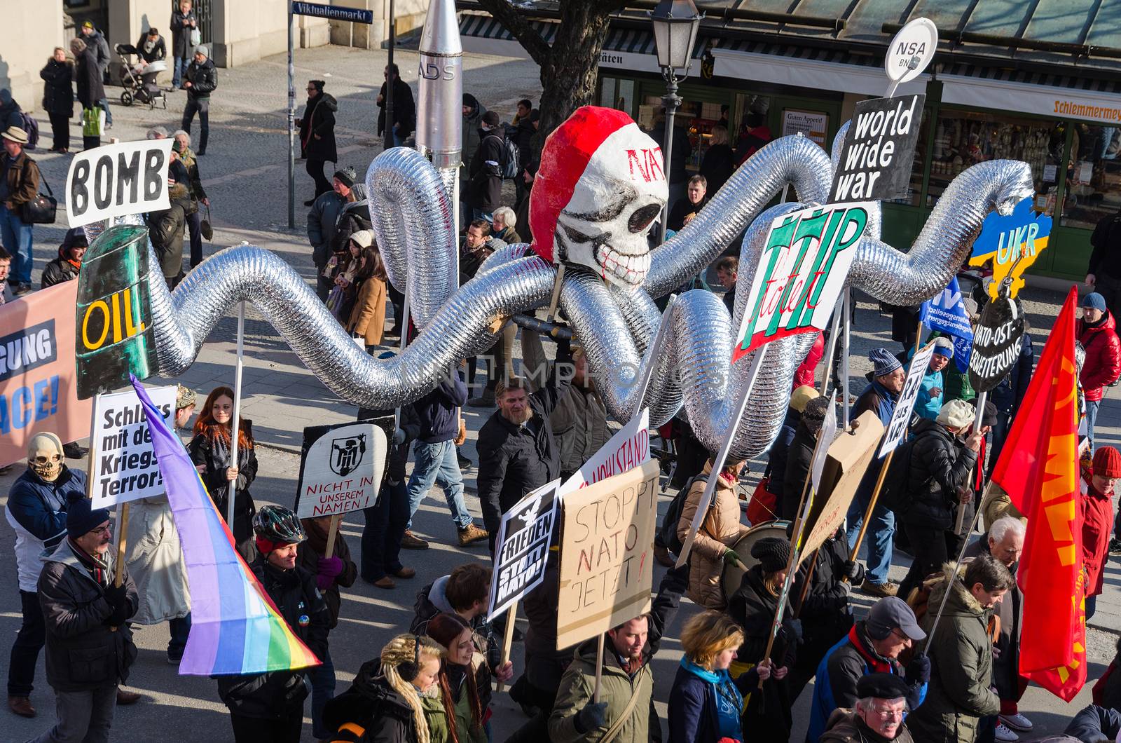 Munich, Germany - February 7, 2015: Antiwar march procession against expansion of presence North Atlantic Alliance in Europe. Protesters and activists are bearing dummy of octopus with NATO skull. 