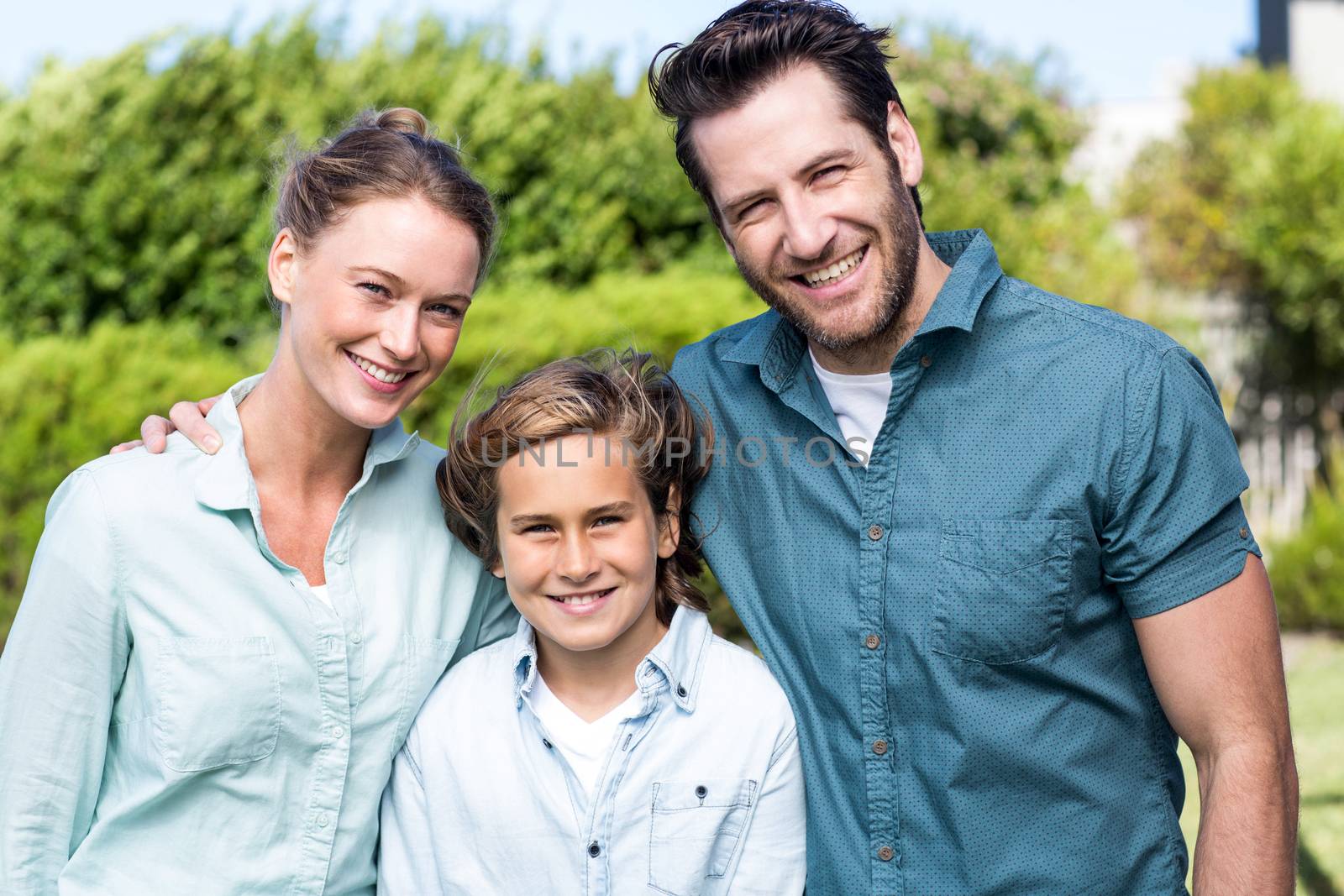 Happy family smiling at camera in the countryside