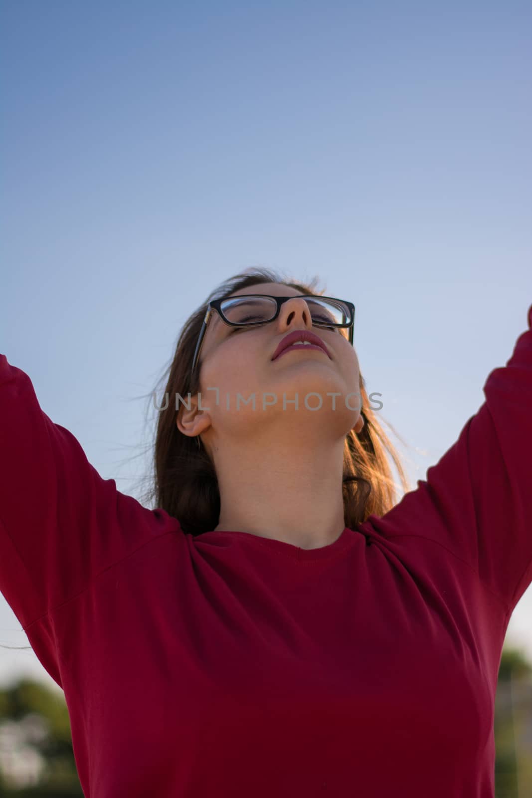 A young beautiful caucasian girl facing the sky.