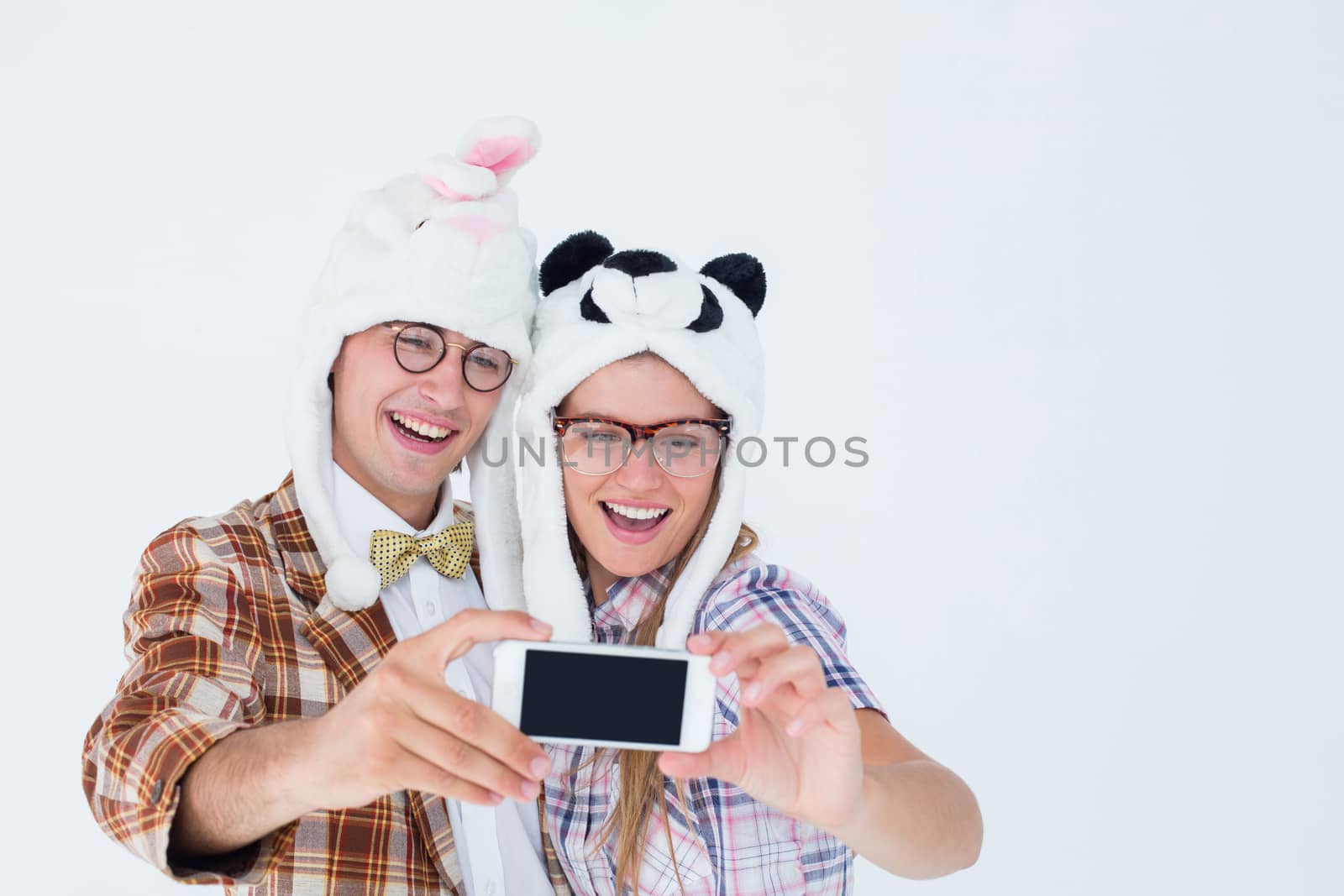 Geeky hipster couple taking selfie with smart phone on white background