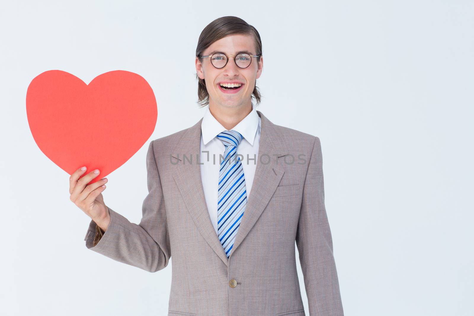 Geeky businessman smiling and holding heart card  by Wavebreakmedia