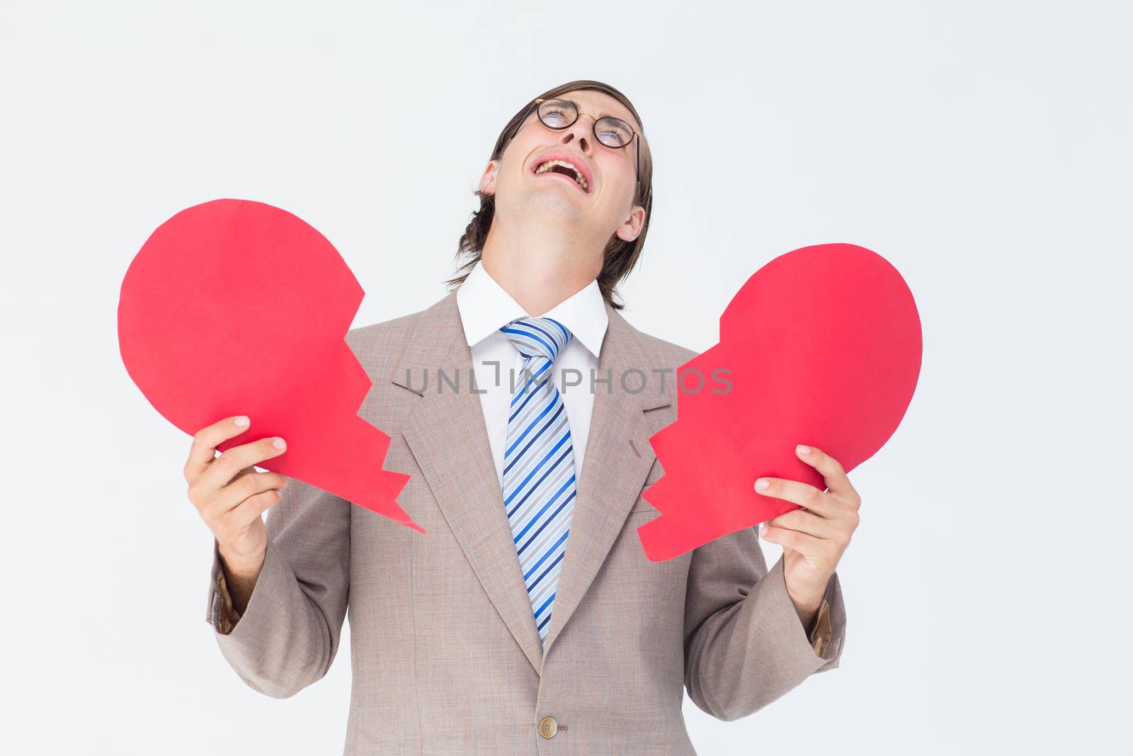 Geeky businessman crying and holding broken heart card by Wavebreakmedia