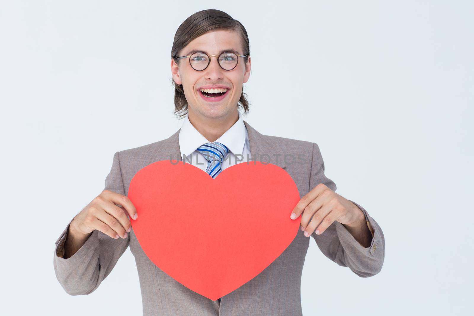 Geeky businessman smiling and holding heart card on white background