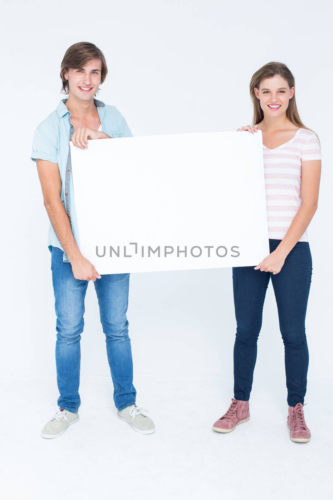 Hipster couple holding poster smiling and at camera on white background