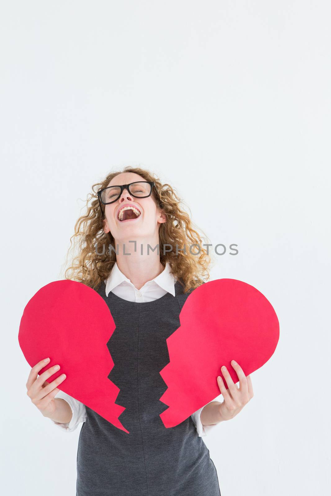 Geeky hipster holding a broken heart card on white background