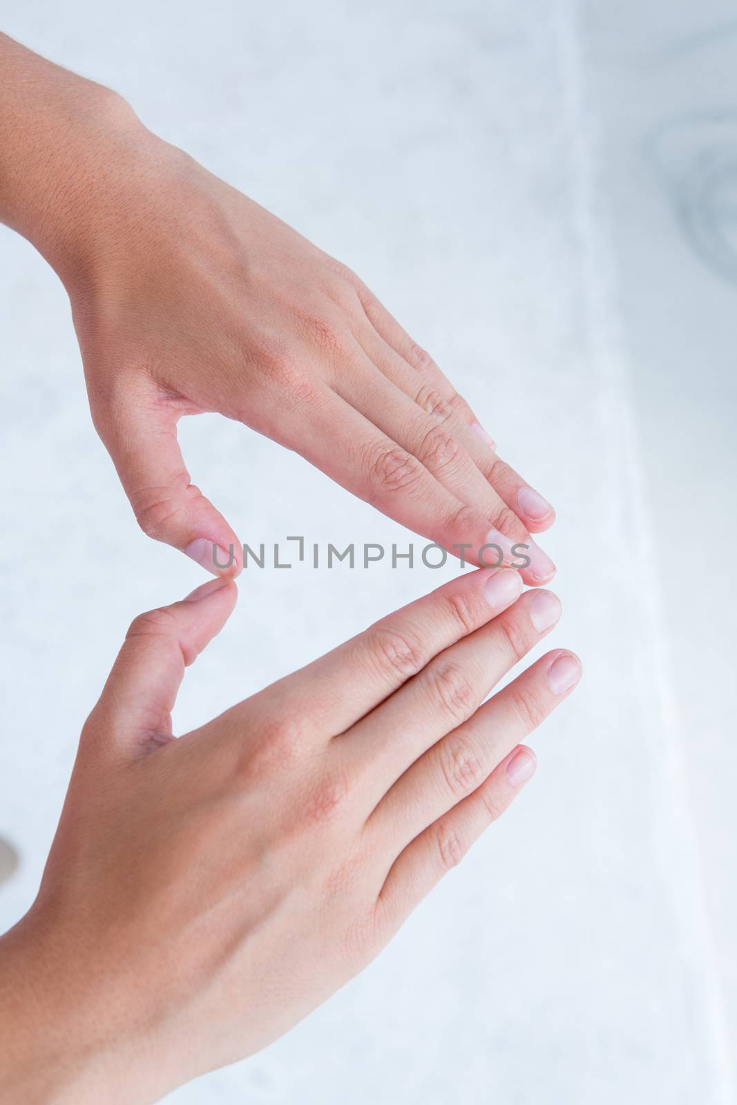Woman making heart shape with hands on white background