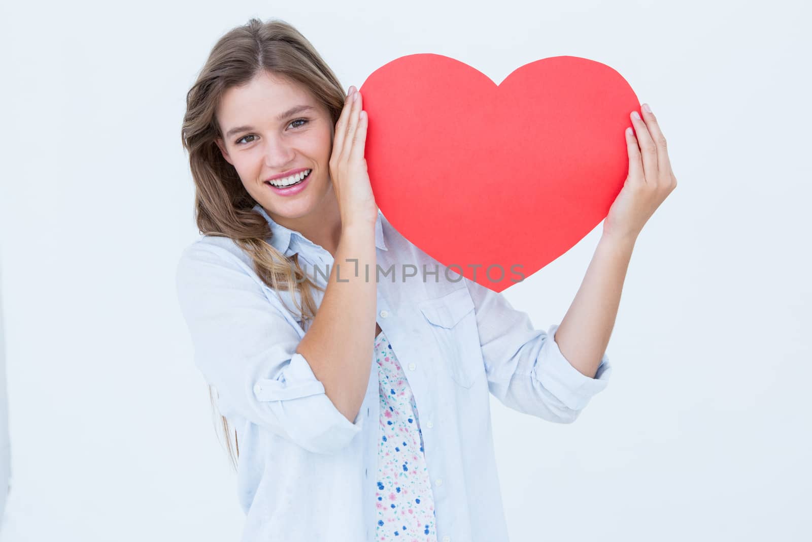 Woman holding heart card  by Wavebreakmedia