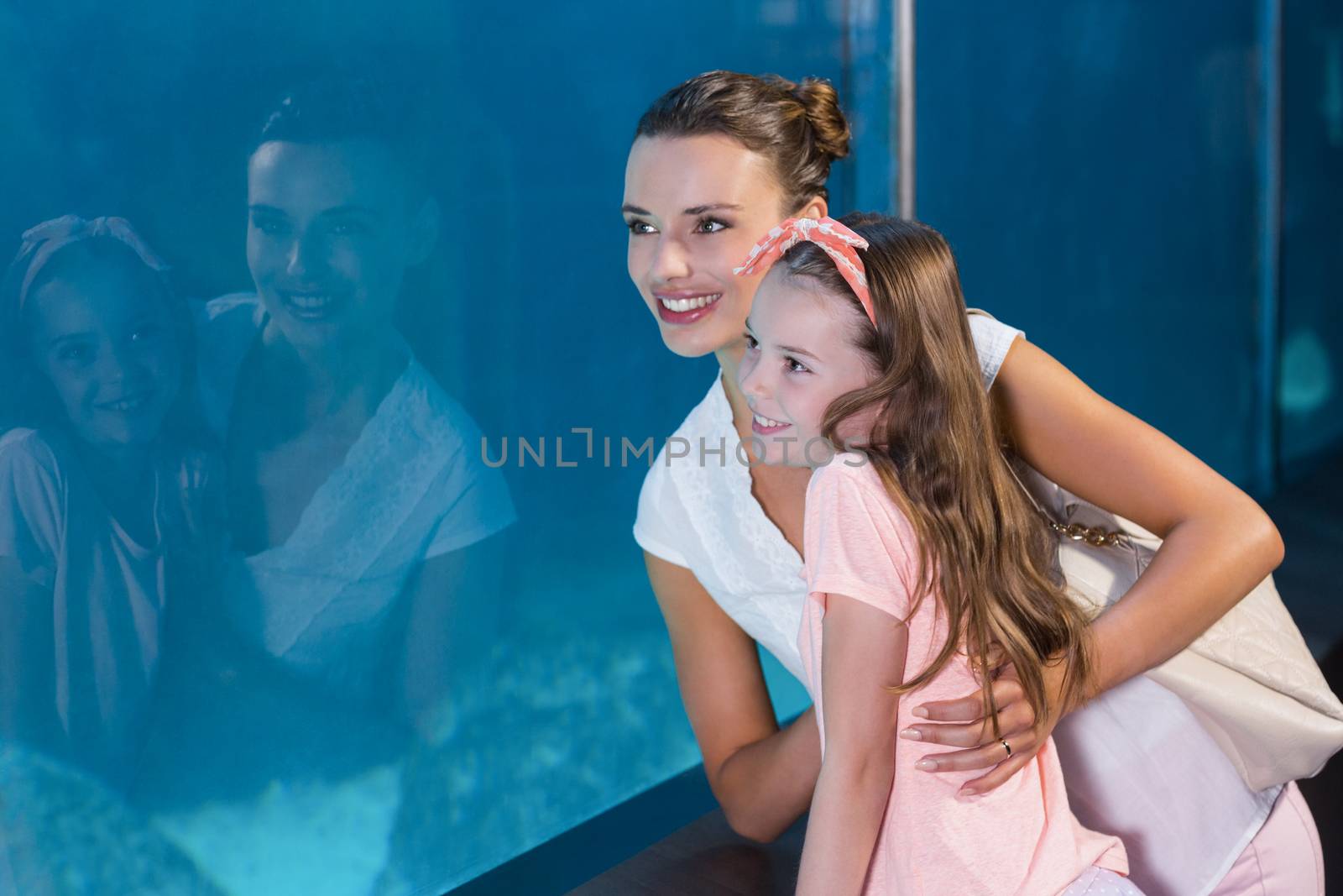 Happy family looking at fish tank by Wavebreakmedia