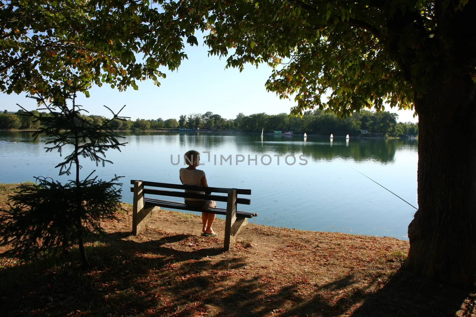 Lady relaxing on the bench ashore of lake