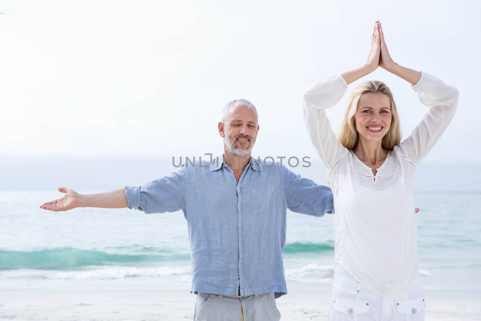Happy couple doing yoga together by Wavebreakmedia