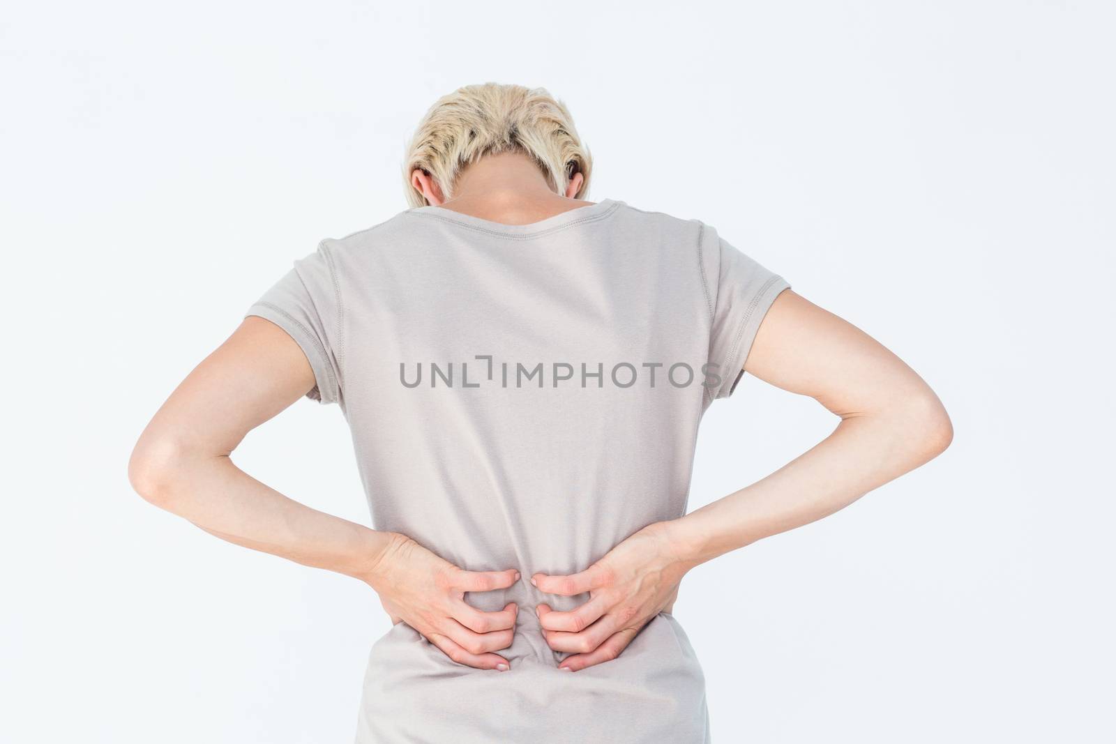 Blonde woman having a back ache and holding her back by Wavebreakmedia