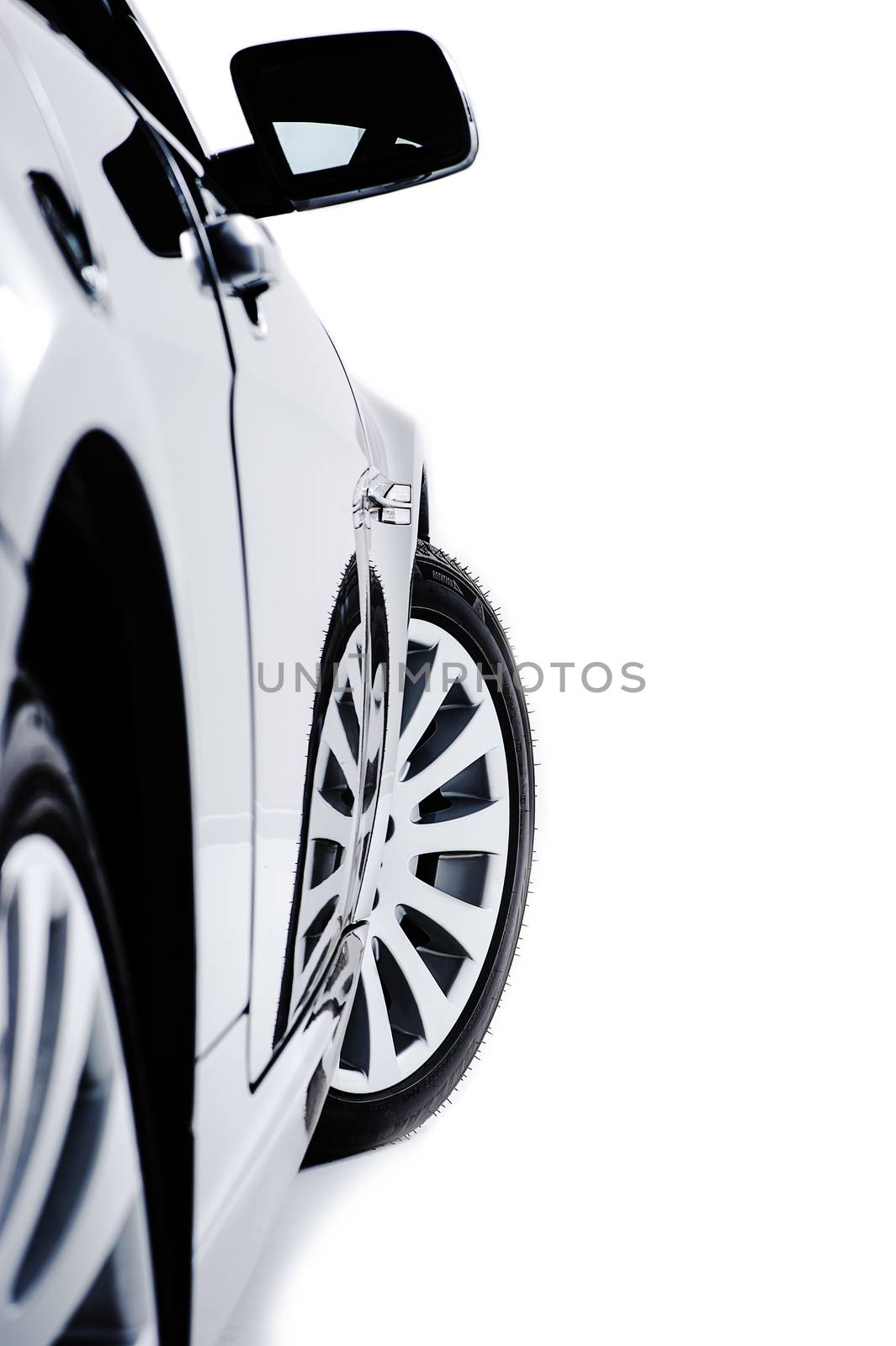 Side bodywork of a modern black car with alloy sport wheels and a protruding wing mirror viewed down the length of the vehicle isolated on white