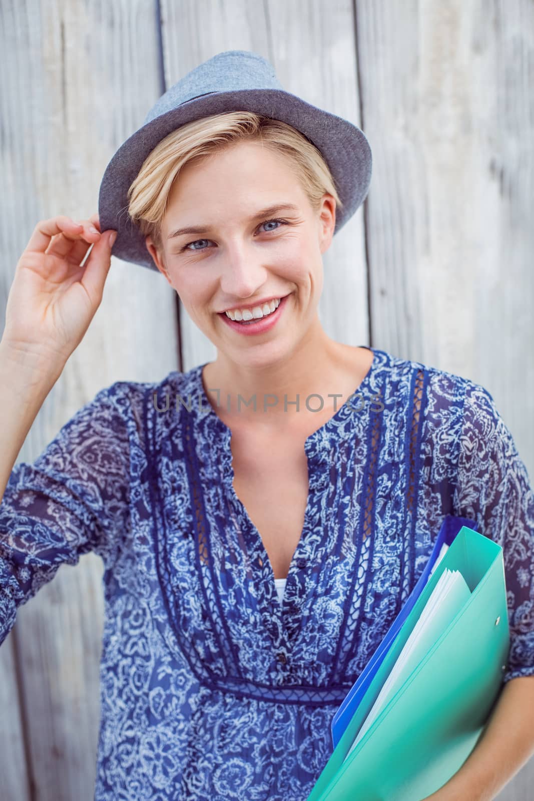 Pretty blonde woman holding folders on wooden background