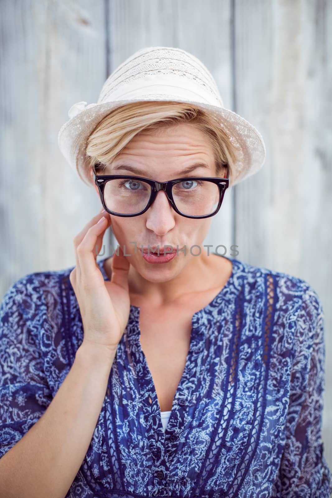 Pretty blonde woman wearing hipster glasses on wooden background